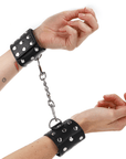 KINK - RESISTENZA DA POLSO CON CHIUSURA A SCATTO COMPLETA DI RIVETTI NERA REGOLABILE 19 - 24 CM X 5,5 CM - KINK WRIST RESTRAINT - Intimo per le occasioni speciali | The Game Lingerie